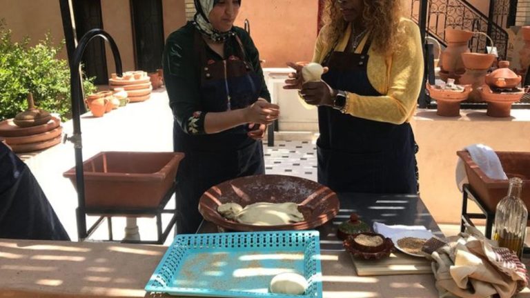 Traditional cooking class in Marrakech, where women prepare Moroccan bread by hand during an authentic culinary experience