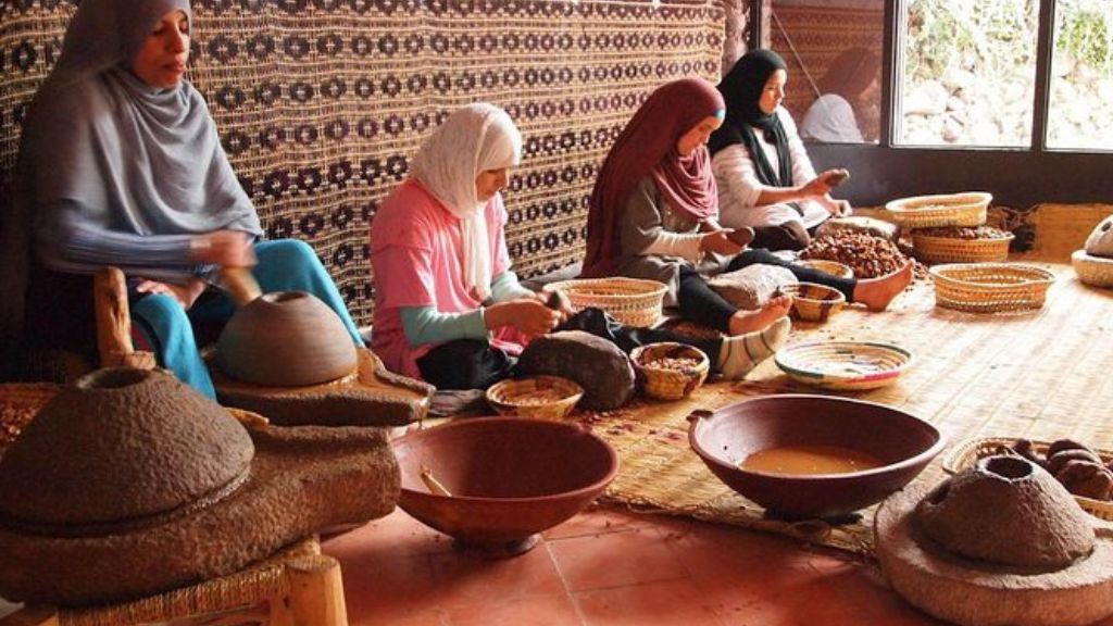 Femmes artisanes dans une coopérative traditionnelle à Marrakech, préparant l’huile d’argan selon des méthodes ancestrales marocaines.