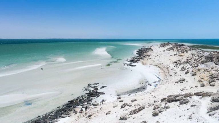 Aerial view of Dakhla peninsula showing Sahara Desert meeting Atlantic Ocean with town and lagoon visible