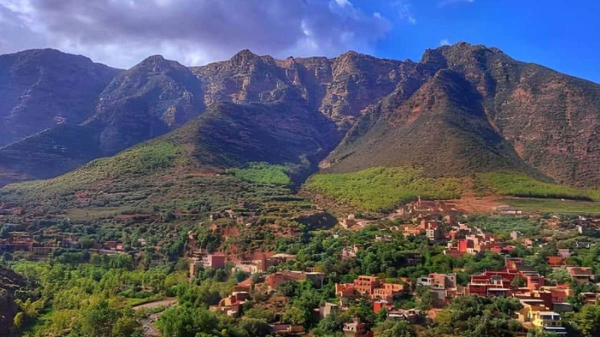 A remote village of red-earth houses and green terraces nestled in the rugged folds of the Anti-Atlas Mountains symbolizing the quiet strength of mountain life where stories are told beneath fig trees, healing unfolds in silence, and tradition is lived, not performed.