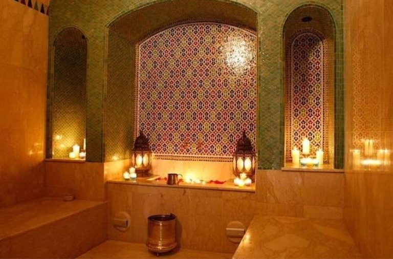A serene hammam chamber adorned with intricate zellige tiles, warm stone benches, and flickering candlelight symbolizing the quiet strength of communal wellness where steam, clay, and silence offer healing not as luxury, but as daily ritual passed through generations.