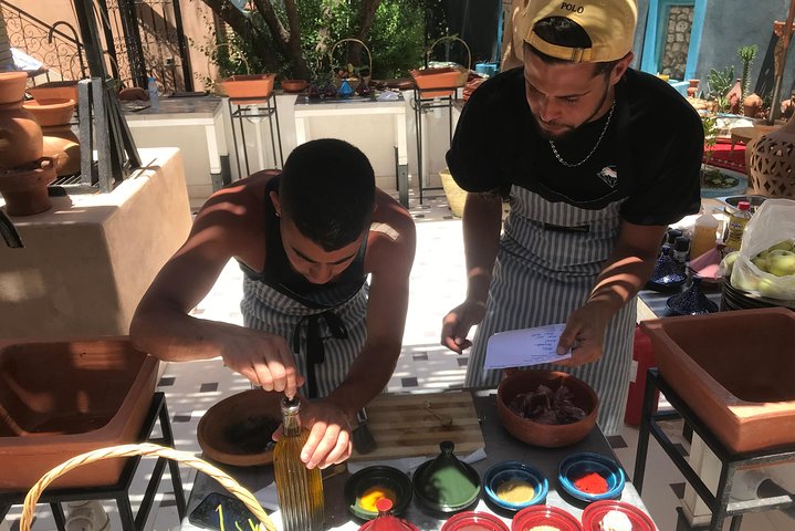 Cooking class participants selecting spices with local instructor at a traditional Marrakech cooking class 