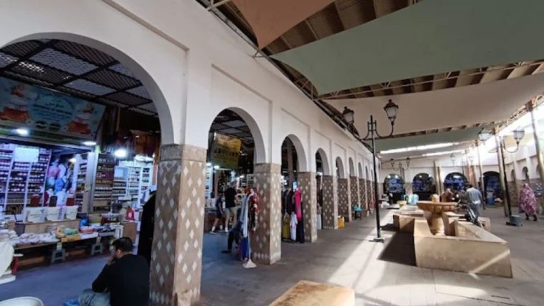 Interior of Souk El Had market in Agadir, featuring traditional Moroccan arches, shaded walkways, and local product stalls.